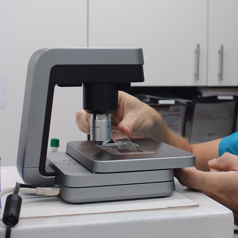 Person adjusting glass slide on a modern zoetis imagyst in a laboratory setting at citivet